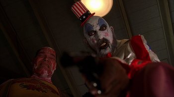 Movie still from “House of 1000 Corpses” (2003), directed by Rob Zombie – Two people in clown costumes and makeup playing a guitar; Medium shot, Low angle