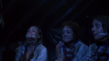 Movie still from “House of 1000 Corpses” (2003), directed by Rob Zombie – Two women with chains around their necks and mouths; Medium shot, Low angle