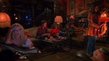 Movie still from “House of 1000 Corpses” (2003), directed by Rob Zombie – A group of people sitting on a couch in a living room; Wide shot, High angle