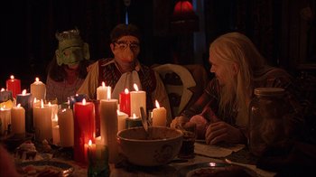 Movie still from “House of 1000 Corpses” (2003), directed by Rob Zombie – A group of people sitting around a table with lit candles; Medium shot, Over the shoulder angle