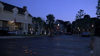 Movie still from “House of 1000 Corpses” (2003), directed by Rob Zombie – A person riding a bike down a street at night; Extreme Wide shot, High angle