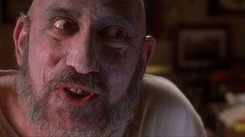 Movie still from “House of 1000 Corpses” (2003), directed by Rob Zombie – An old man with a strange look on his face; Extreme Close Up shot, Low angle
