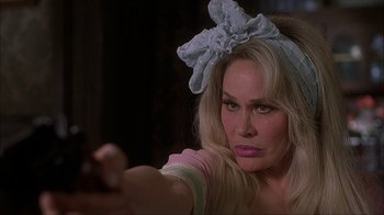 Movie still from “House of 1000 Corpses” (2003), directed by Rob Zombie – A woman with a bow on her head is pointing a gun; Close Up shot, Over the shoulder angle