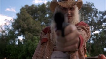 Movie still from “House of 1000 Corpses” (2003), directed by Rob Zombie – A man in a cowboy hat holding a gun in his hand; Close Up shot, Low angle