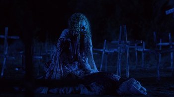 Movie still from “House of 1000 Corpses” (2003), directed by Rob Zombie – A woman sitting on the ground next to a grave; Wide shot, Low angle