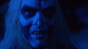 Movie still from “House of 1000 Corpses” (2003), directed by Rob Zombie – A person with a blue makeup; Close Up shot, Low angle