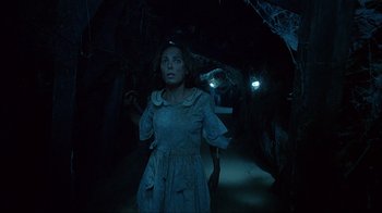 Movie still from “House of 1000 Corpses” (2003), directed by Rob Zombie – A woman standing in the dark in front of trees; Medium shot, Low angle