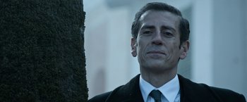 Movie still from “House of Gucci” (2021), directed by Ridley Scott – A person wearing a suit and tie; Close Up shot, Low angle