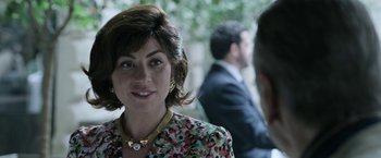 Movie still from “House of Gucci” (2021), directed by Ridley Scott – A person wearing a floral dress; Close Up shot, Over the shoulder angle