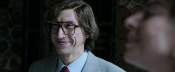Movie still from “House of Gucci” (2021), directed by Ridley Scott – A person wearing glasses and a suit; Close Up shot, Over the shoulder angle