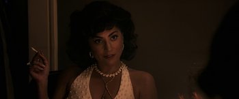 Movie still from “House of Gucci” (2021), directed by Ridley Scott – A woman in a white dress with a pearl necklace; Close Up shot, Over the shoulder angle