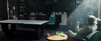 Movie still from “House of Gucci” (2021), directed by Ridley Scott – Smoke coming out of a table; Wide shot, High angle