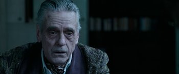 Movie still from “House of Gucci” (2021), directed by Ridley Scott – An old man with a gray hair sitting in a room; Close Up shot, Over the shoulder angle
