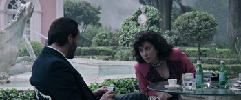 Movie still from “House of Gucci” (2021), directed by Ridley Scott – A man and a woman sitting next to each other; Medium shot, Over the shoulder angle