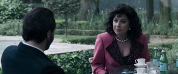 Movie still from “House of Gucci” (2021), directed by Ridley Scott – A woman in a pink jacket sitting next to a man; Close Up shot, Over the shoulder angle