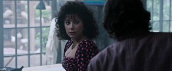 Movie still from “House of Gucci” (2021), directed by Ridley Scott – A woman in a polka dot dress looking into a mirror; Close Up shot, Over the shoulder angle