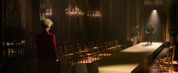 Movie still from “House of Gucci” (2021), directed by Ridley Scott – A row of chairs in the middle of a room; Extreme Wide shot, Over the shoulder angle