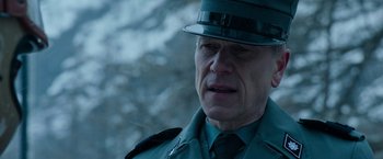 Movie still from “House of Gucci” (2021), directed by Ridley Scott – An older man in a uniform is looking down; Close Up shot, Over the shoulder angle