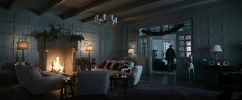 Movie still from “House of Gucci” (2021), directed by Ridley Scott – A living room filled with furniture next to a fire place; Extreme Wide shot, Low angle