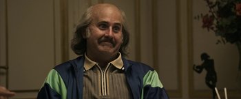 Movie still from “House of Gucci” (2021), directed by Ridley Scott – An older man with a bald head and a mustache; Close Up shot, Low angle