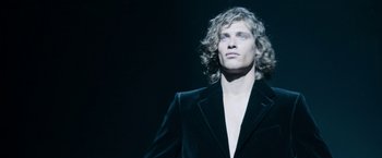 Movie still from “House of Gucci” (2021), directed by Ridley Scott – A man in a black suit is looking up; Close Up shot, Low angle