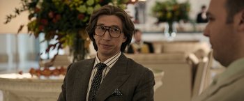 Movie still from “House of Gucci” (2021), directed by Ridley Scott – A man in a suit and tie wearing glasses; Close Up shot, Over the shoulder angle