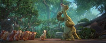 Movie still from “Ice Age: Continental Drift” (2012), directed by Michael Thurmeier – A group of animals sitting on top of a dirt field next to trees; Wide shot, Low angle