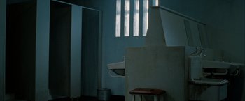 Movie still from “Hunger” (2008), directed by Steve McQueen – A bathroom with a sink , toilet , and mirror in it; Wide shot, High angle