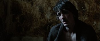 Movie still from “Hunger” (2008), directed by Steve McQueen – A man in a robe looking at the camera; Close Up shot, High angle