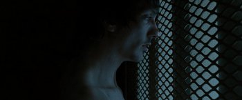Movie still from “Hunger” (2008), directed by Steve McQueen – A man looking out of a window at night; Close Up shot, Low angle