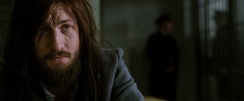 Movie still from “Hunger” (2008), directed by Steve McQueen – A person with long hair and a beard; Close Up shot, Low angle