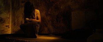Movie still from “Hunger” (2008), directed by Steve McQueen – A man sitting on the ground in a dark room; Medium shot, High angle