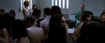 Movie still from “Hunger” (2008), directed by Steve McQueen – A group of people standing in a room; Medium shot, Over the shoulder angle
