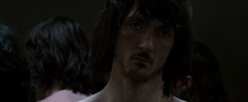Movie still from “Hunger” (2008), directed by Steve McQueen – A person with long black hair; Close Up shot, Over the shoulder angle