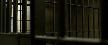 Movie still from “Hunger” (2008), directed by Steve McQueen – A cat sitting on top of a metal fence; Extreme Close Up shot, Low angle