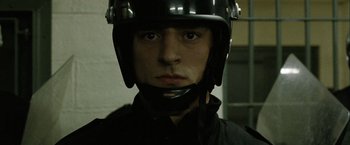 Movie still from “Hunger” (2008), directed by Steve McQueen – A person wearing a helmet and a black jacket; Close Up shot, Low angle