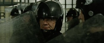 Movie still from “Hunger” (2008), directed by Steve McQueen – A man wearing a black helmet and a black jacket; Close Up shot, Over the shoulder angle