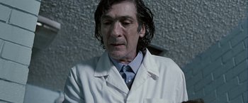 Movie still from “Hunger” (2008), directed by Steve McQueen – A person wearing a lab coat; Close Up shot, Low angle