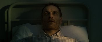 Movie still from “Hunger” (2008), directed by Steve McQueen – A person laying in a hospital bed; Close Up shot, Low angle