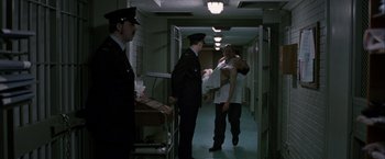 Movie still from “Hunger” (2008), directed by Steve McQueen – A man holding a baby in his arms in a hospital hallway; Wide shot, High angle