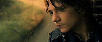Movie still from “Hunger” (2008), directed by Steve McQueen – A young woman looking out a window at the street; Close Up shot, Low angle