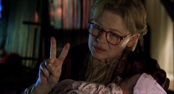 Movie still from “I Am Sam” (2001), directed by Jessie Nelson – An older woman wearing glasses making a peace sign; Close Up shot, Over the shoulder angle