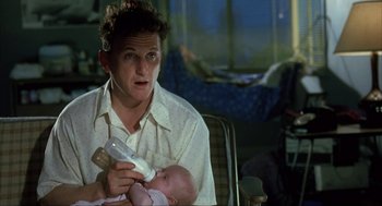 Movie still from “I Am Sam” (2001), directed by Jessie Nelson – A man holding a baby in his arms while sitting in a chair; Close Up shot, Low angle