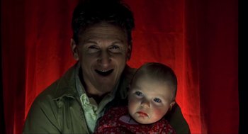 Movie still from “I Am Sam” (2001), directed by Jessie Nelson – A man holding a baby in his arms and smiling; Close Up shot, Low angle