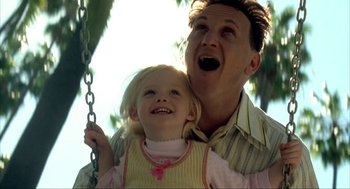 Movie still from “I Am Sam” (2001), directed by Jessie Nelson – A man and a little girl are on a swing; Close Up shot, Low angle