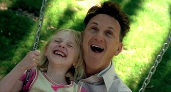 Movie still from “I Am Sam” (2001), directed by Jessie Nelson – A man and a little girl smiling for the camera; Close Up shot, Low angle
