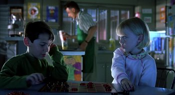 Movie still from “I Am Sam” (2001), directed by Jessie Nelson – Two young children are playing a game in a kitchen; Close Up shot, Over the shoulder angle