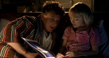 Movie still from “I Am Sam” (2001), directed by Jessie Nelson – A man and a little girl looking at a book; Medium shot, Over the shoulder angle