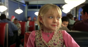 Movie still from “I Am Sam” (2001), directed by Jessie Nelson – A little girl sitting at a table in front of a group of people; Close Up shot, Over the shoulder angle