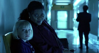 Movie still from “I Am Sam” (2001), directed by Jessie Nelson – A woman sitting next to a young girl in a hallway; Close Up shot, Over the shoulder angle